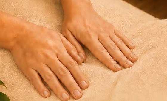 Mains d'une praticienne pendant un massage du dos